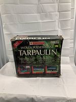 Motomaster woven polyethylene tarpaulin in original box, front view showing product name and size