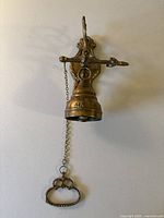 Full view of cast brass swing bell mounted on wall