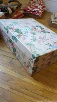 Photo of largest rectangular floral nesting box with pink background, placed on wood floor