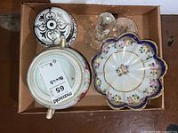 Top-down view showing all items in a cardboard box: Nippon decorated scalloped bowl, lidded sugar bowl, glass coaster, clear crystal trinket.