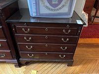 Front view of cherry-finish chest with four drawers and glass top