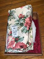 Folded pillow shams showing a large floral rose pattern with a tag labeling Pillow Shams and More.