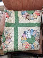 Full quilt folded to show large floral appliqué on cream and green background
