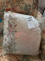 First quilt with cream color and floral embroidery, photographed to show intricate needlework and quilting detail