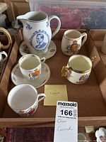 Top view of the King Edward Royal China pieces grouped in a box showing the pitcher, cups, and saucer.