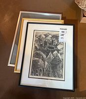 Front view of framed engraving leaning on the floor showing distinctive architectural imagery in black and white.