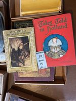 Photo showing 'Siegfried & The Twilight of the Gods' by Arthur Rackham and 'Tales Told in Holland' with a red cover.