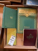 Four hardcover books in a cardboard box