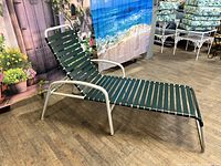 Side angled view of the chaise lounge showing light gray powder coated aluminum frame with new dark green straps and adjustable backrest.