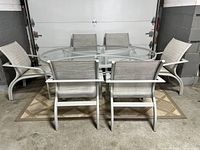 Front view of oval glass-top table surrounded by six chairs