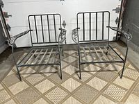 Pair of vintage wrought iron club chairs side by side, showing front and top views, placed on patterned floor.