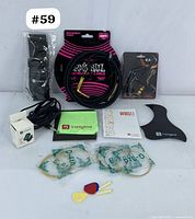 Full lot showing Ernie Ball cable, Vangoa tuner, capo, guitar strings, picks, bridge pins, cleaning cloth and manuals
