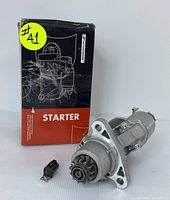 Front view of starter motor and relay with original box showing label and item number sticker.