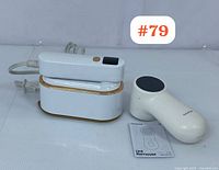 Photo showing the Gaiatop Q11 lint remover and FG-S12 steam iron placed side by side on a white surface