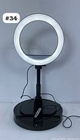 Front view of Mobifoto ring light fully lit, showing round LED diffuser and base with control panel