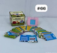 View of the complete lot showing the pink voice card reader, original box, and fan array of colorful flashcards spread out in front.