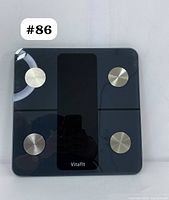 Top view of Vitafit smart body fat digital scale showing four metal sensors and central display area with Vitafit logo.