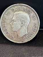 Close-up front side of the 1941 Canadian 50 cent silver coin showing King George VI profile with stamped text.