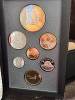 Reverse side showing coin designs including mining scene on the double dollar coin, caribou on 25 cents, beaver on 5 cents, loon on 1 dollar and 1988 date on all.