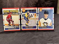 Three 1990-91 Score hockey rookie cards featuring Jaromir Jagr (Pittsburgh Penguins), Eric Lindros (Future Superstar, Philadelphia Flyers), and Mats Sundin (Quebec Nordiques) laid out on a dark fabric background.
