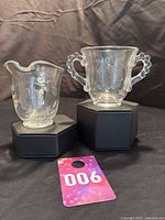 Both creamer and sugar bowl shown on black boxes, highlighting their size and handles