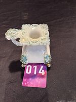 Top and front view of the white milk glass chamberstick candle holder with finger loop and square candle cup decorated with painted accents.