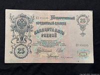 Front side of 1909 Russian 25 rubles banknote with serial number, denomination, floral motif and Cyrillic inscriptions.