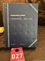 Front cover of dark blue Whitman Canadian Dime Album with gold embossed text and border decoration.
