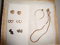 All jewellery pieces laid in box: three earring pairs, ring, bracelet