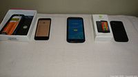 Three phones, two cases and Motorola box laid out