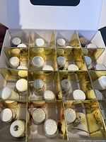 Open box showing grid of dividers filled with porcelain thimbles