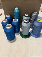 Group shot of eight large blue thread cones