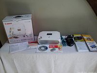 All lot contents laid out: printer, box, cords, CD, manuals, photo paper