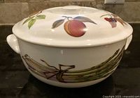 Side view of lidded porcelain dish showing peach and asparagus motifs