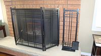 Screen and tool set displayed in front of fireplace
