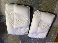 Two white Tony Little Sleep Pillows side by side on carpet