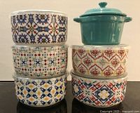 Front view of stacked patterned bowls and teal Cuisinart dish