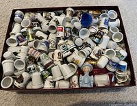 Top view of box filled with over 200 mixed thimbles showing variety of designs and materials