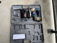 Open carry case showing jigsaw, battery, charger, accessory box and papers