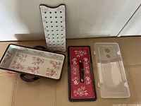 All four components laid out: loaf pan, perforated insert, decorative lid, clear plastic cover