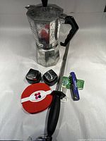 Full display of the espresso maker, sharpening steel, whiskey rocks, corkscrew, beer opener, and coasters on a white surface.