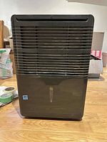 Front view of black Danby dehumidifier showing air intake grille and water level indicator.