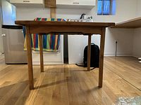 Side view of the pine table showing thickness and leg structure.