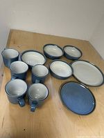 Full set showing plates, bowls, and mugs arranged on a wood surface.