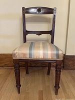 Full view of the vintage stripped wood chair with upholstered seat showing turned front legs and carved wood details.