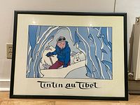 Framed Tintin au Tibet poster with Tintin and Snowy in a snow cave and text underneath