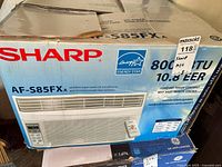 Boxed Sharp air conditioner unit model AF-S85FX, showing brand, model, and Energy Star logo.