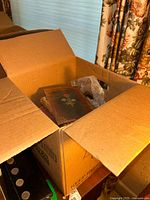Box labeled 'Antique Leather Books' partially opened showing leather bound books inside, some with embossed floral covers.