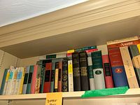 Shelf of assorted literature books including 'Math in Venice' and 'War and Peace'