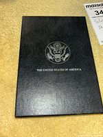 Closed black leatherette presentation case with US seal on cover